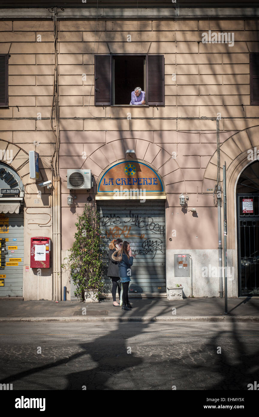 Un uomo guarda il mondo passare dalla sua finestra su Via Galvani, Roma, lazio, Italy. Foto Stock