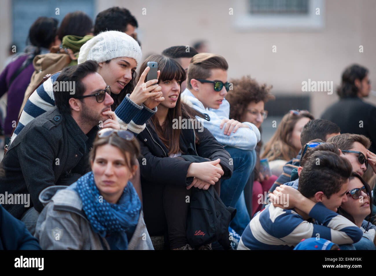 Un gruppo di studenti seduti intorno a Piazza di Santa Maria, Trastevere, Roma, lazio, Italy. Foto Stock