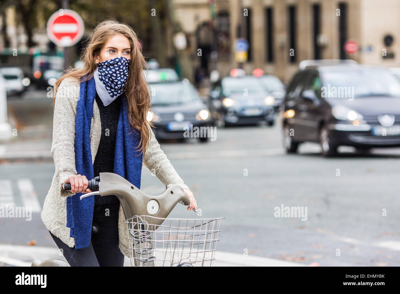 La donna a cavallo di un bicyle in un ambiente urbano. Foto Stock