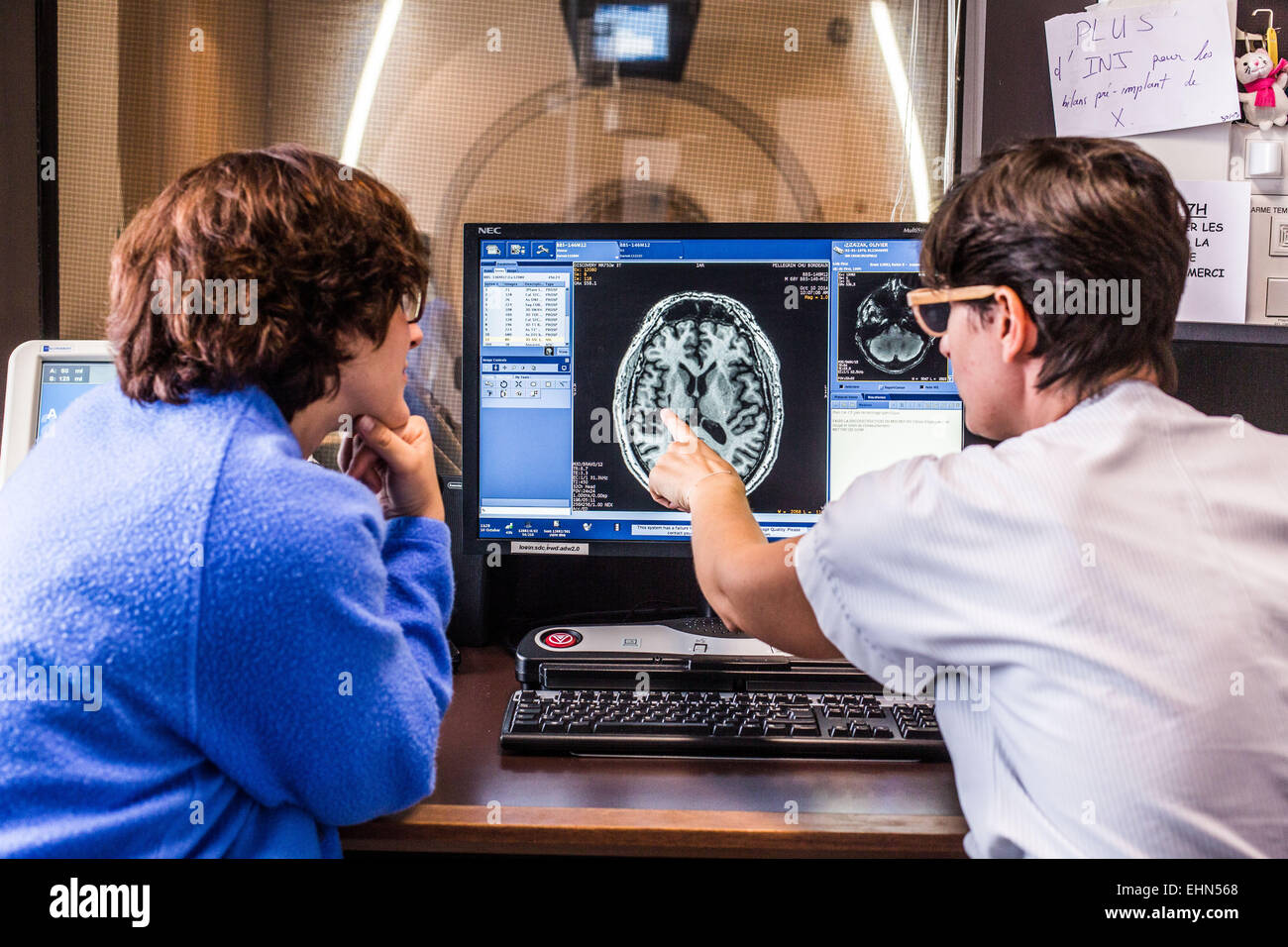 I medici monitore un paziente sottoposto a una tomografia computerizzata (CT) scansione del cervello, ospedale di Bordeaux, Francia. Foto Stock