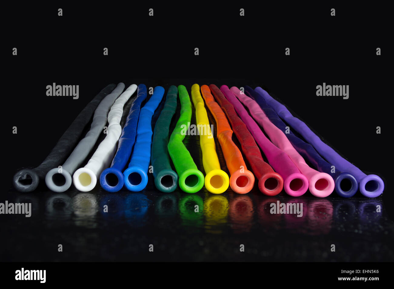 Rainbow di coloratissimi ONU-palloncini gonfiati allineate su sfondo nero Foto Stock