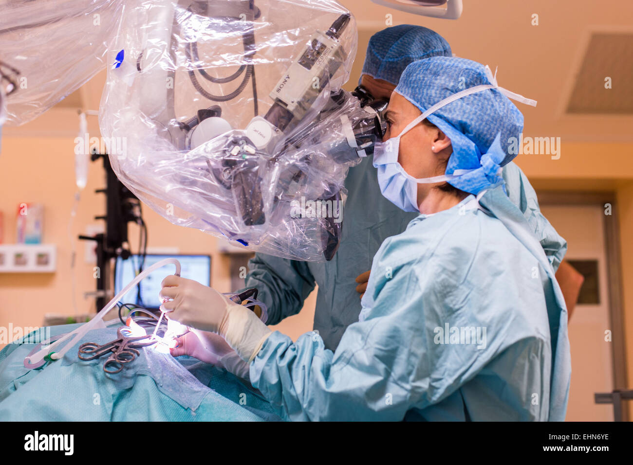 Chirurgo di eseguire impianto cocleare chirurgia, un'operazione di impiantazione di un piccolo dispositivo elettronico utilizzato per fornire un senso di suono a una persona non udente, ospedale di Limoges, Francia. Foto Stock