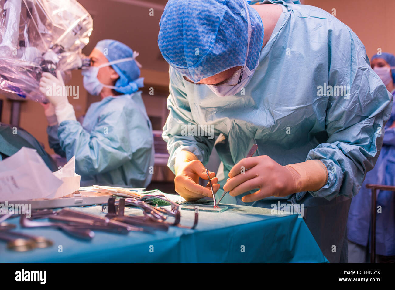 Chirurgo di eseguire impianto cocleare chirurgia, un'operazione di impiantazione di un piccolo dispositivo elettronico utilizzato per fornire un senso di suono a una persona non udente, ospedale di Limoges, Francia. Foto Stock