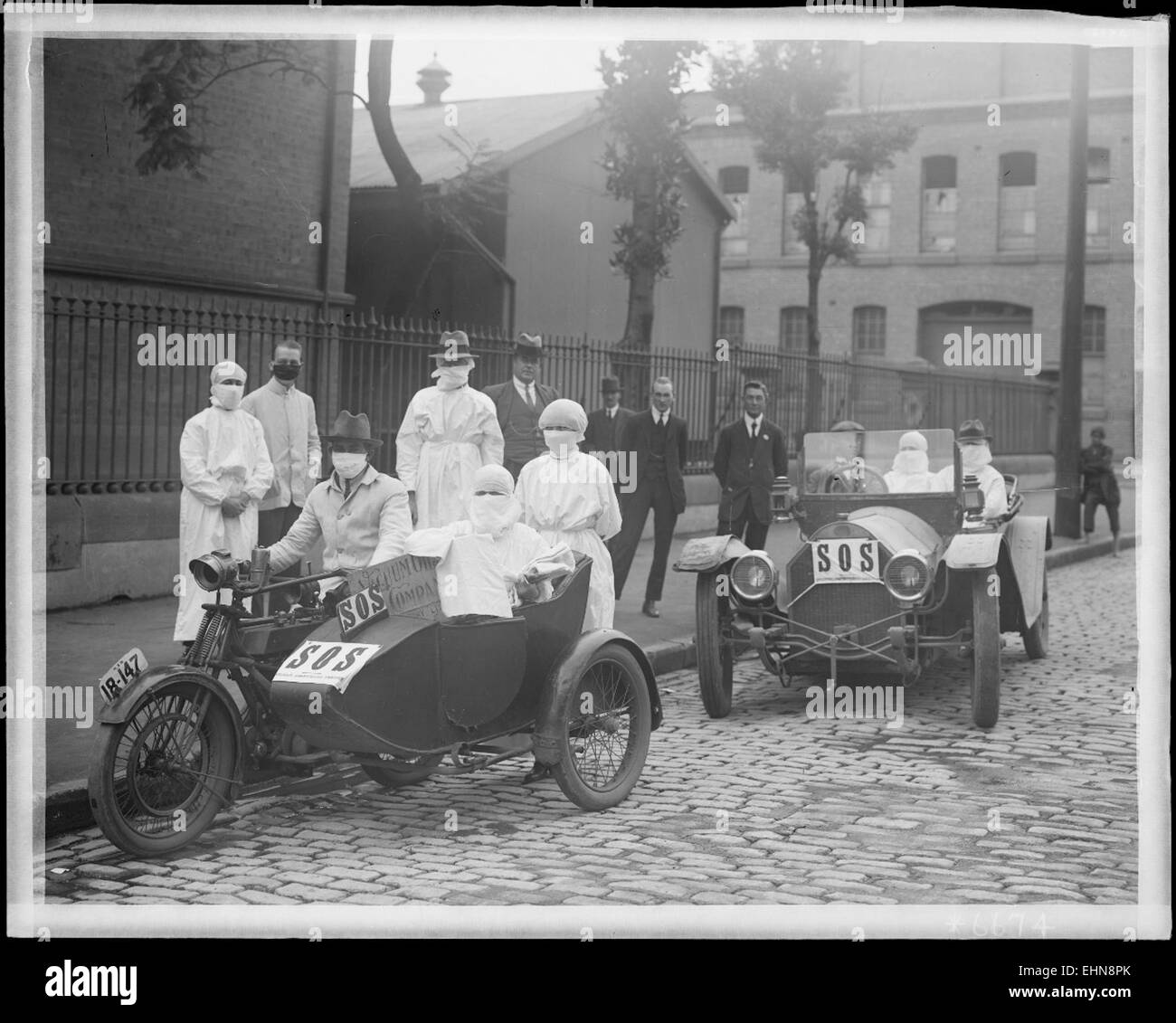 Questa fotografia storica mostra le infermiere che lasciano il deposito di Blackfriars a Chippendale, nel nuovo Galles del Sud, durante l'epidemia di influenza. L'immagine cattura la dedizione degli operatori sanitari durante la pandemia influenzale del 1919, un momento significativo nella storia medica dell'Australia. Foto Stock
