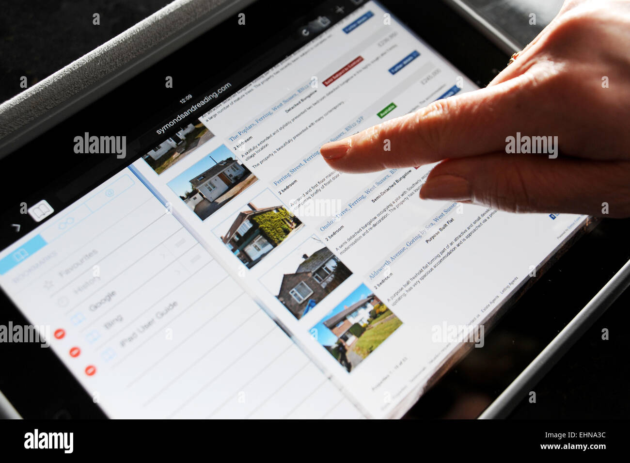 Utilizzando un iPad di Apple per cercare casa a comprare sulla proprietà Symonds e la lettura di agente immobiliare sito Worthing Regno Unito Foto Stock