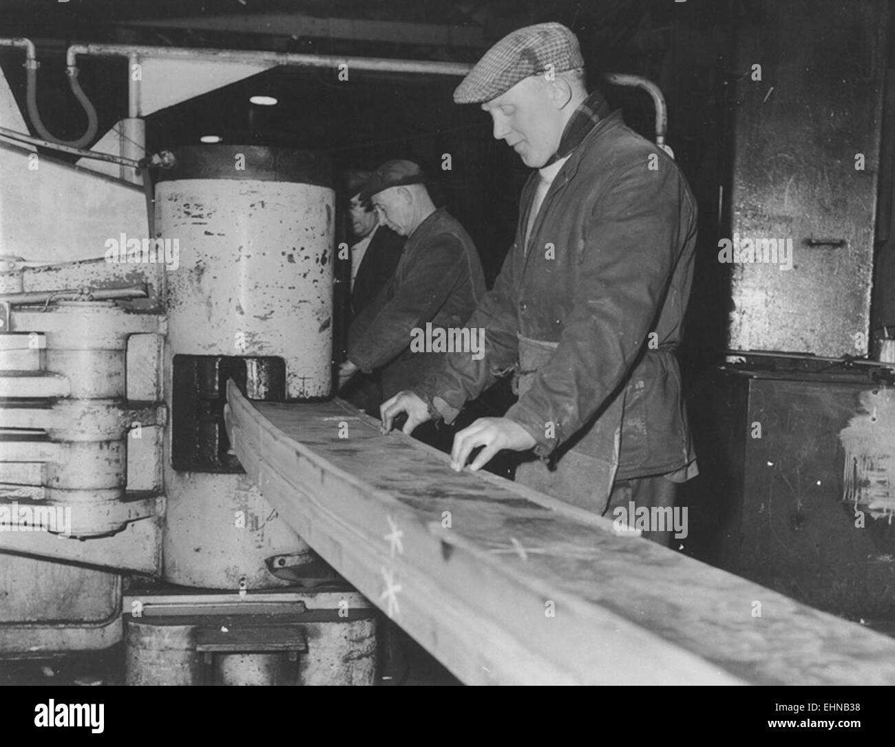 Una fotografia in bianco e nero che cattura i lavoratori dei cantieri navali in una macchina piegatubi a telaio freddo a Sunderland, Inghilterra, durante i primi anni '1960, evidenziando le operazioni industriali in un importante cantiere navale. Foto Stock