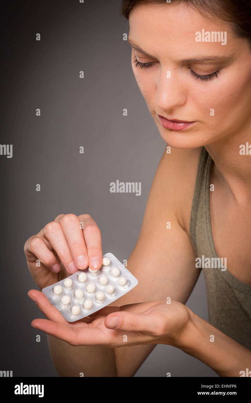 Donna prendendo una terapia di sostituzione ormonale pillole. Foto Stock