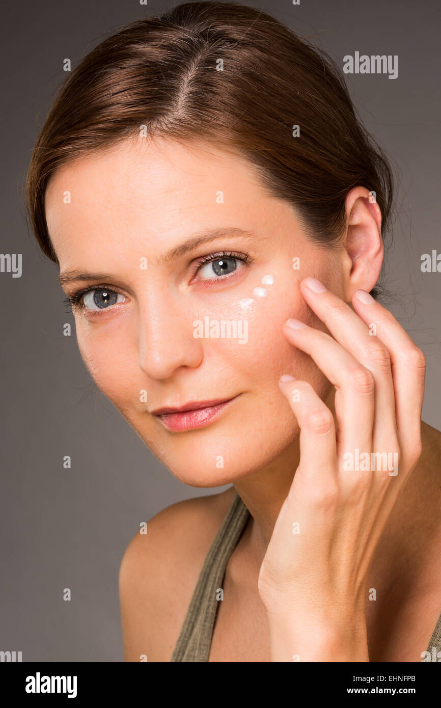 Donna l'applicazione di crema anti-rughe intorno agli occhi. Foto Stock