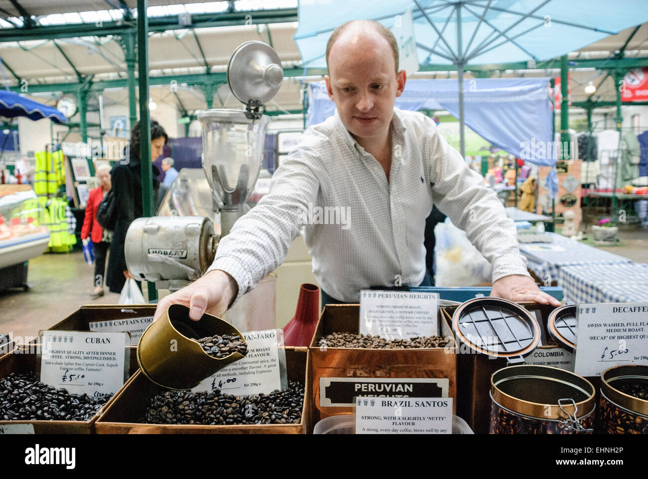 Misure uomo fuori una quantità di chicchi di caffè in un mercato in stallo Foto Stock