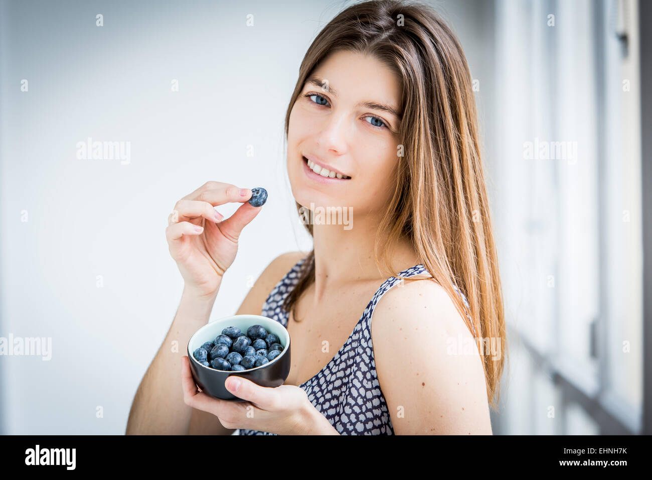 Donna di mangiare mirtilli. Foto Stock