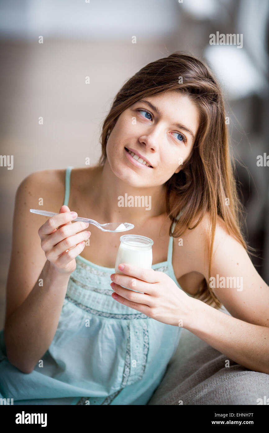 Donna di mangiare yogurt. Foto Stock