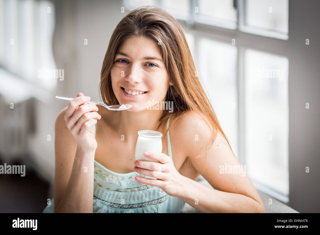 Donna di mangiare yogurt. Foto Stock