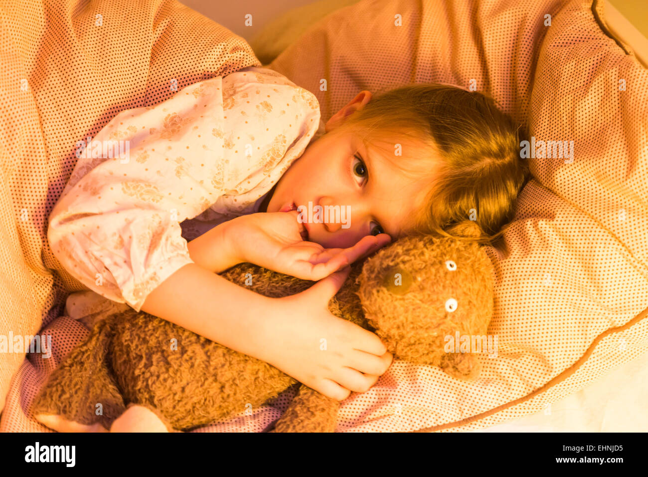 5 anno-vecchia ragazza sdraiato sul letto. Foto Stock