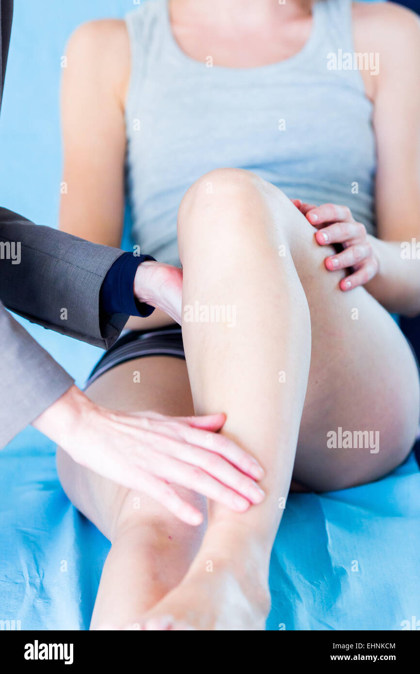 Medico esaminando le gambe di una donna. Foto Stock