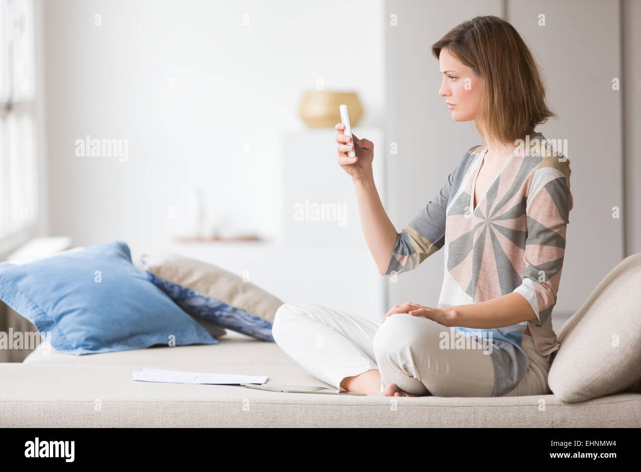 Donna toccando lo schermo di un iphone®. Foto Stock