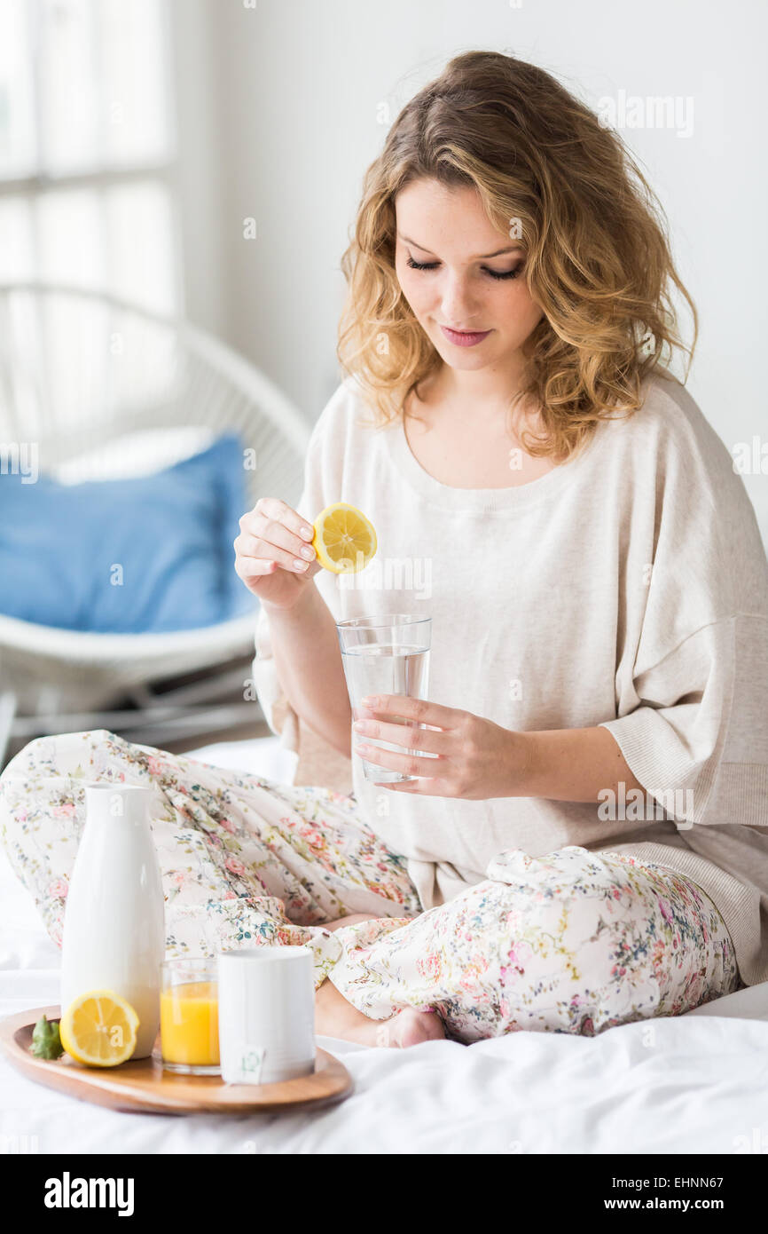 Donna di bere spremuta di succo di limone. Foto Stock