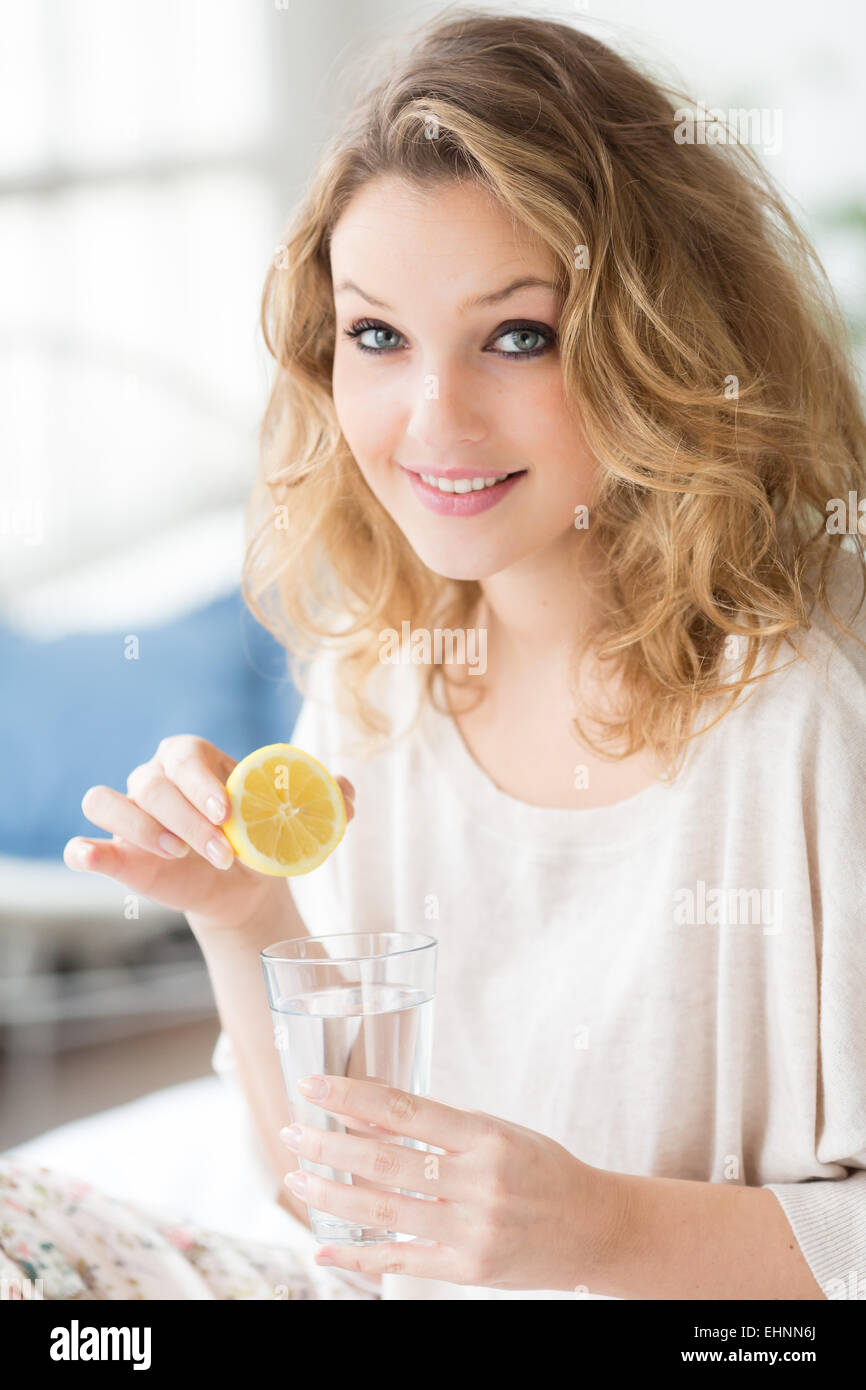 Donna di bere spremuta di succo di limone. Foto Stock