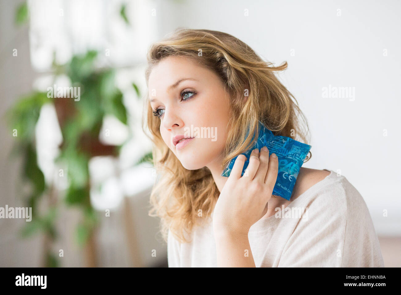 Donna che utilizza un caldo-freddo pacco gel per il trattamento del dolore releive. Foto Stock