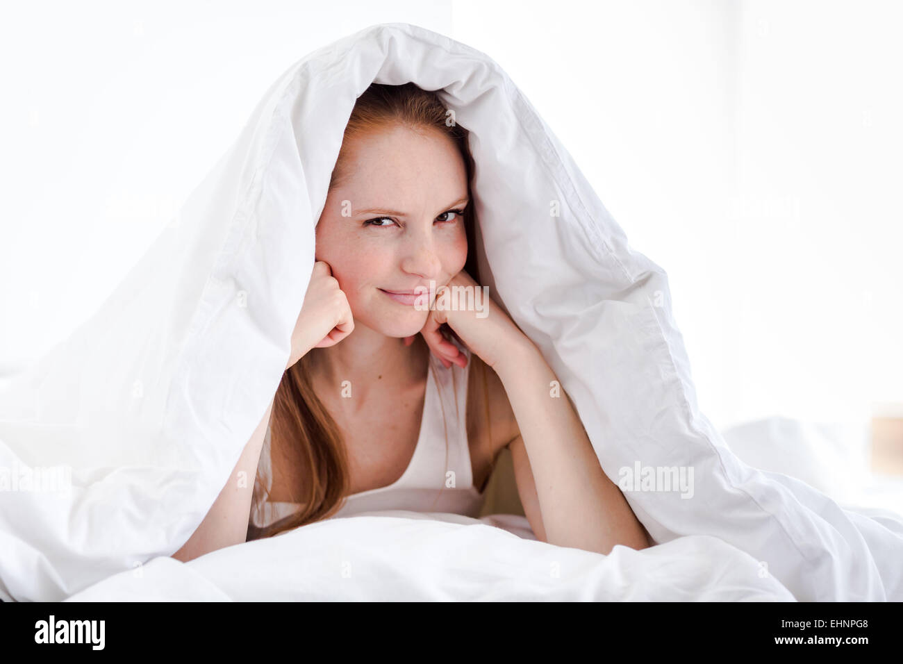 Donna seduta sul letto. Foto Stock