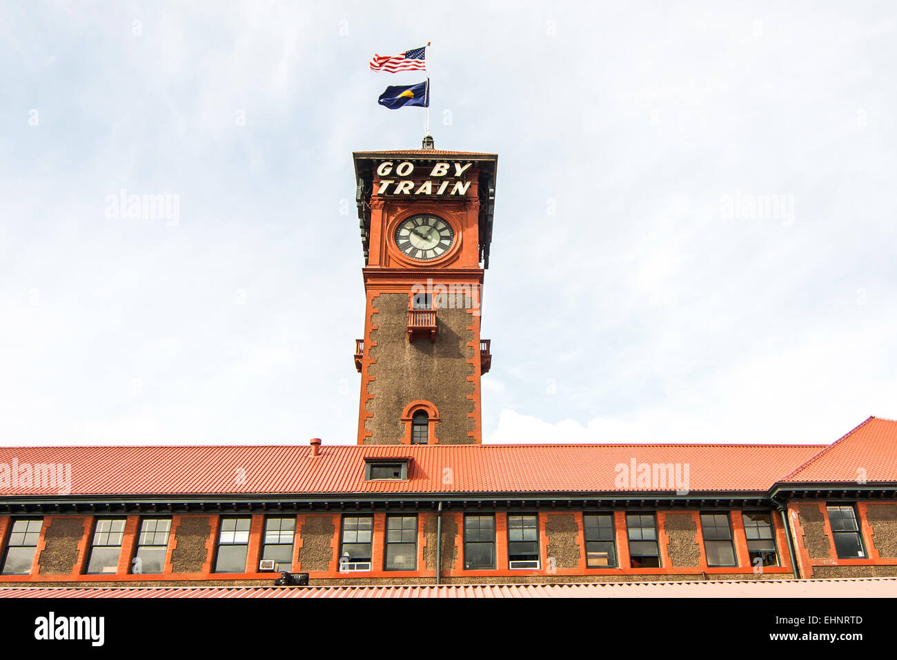 La torre dell'orologio al di sopra del Portland la Stazione Ferroviaria di Amtrak in Portland, Oregon, Stati Uniti d'America. Il segno spinge le persone ad "andare in treno". Foto Stock