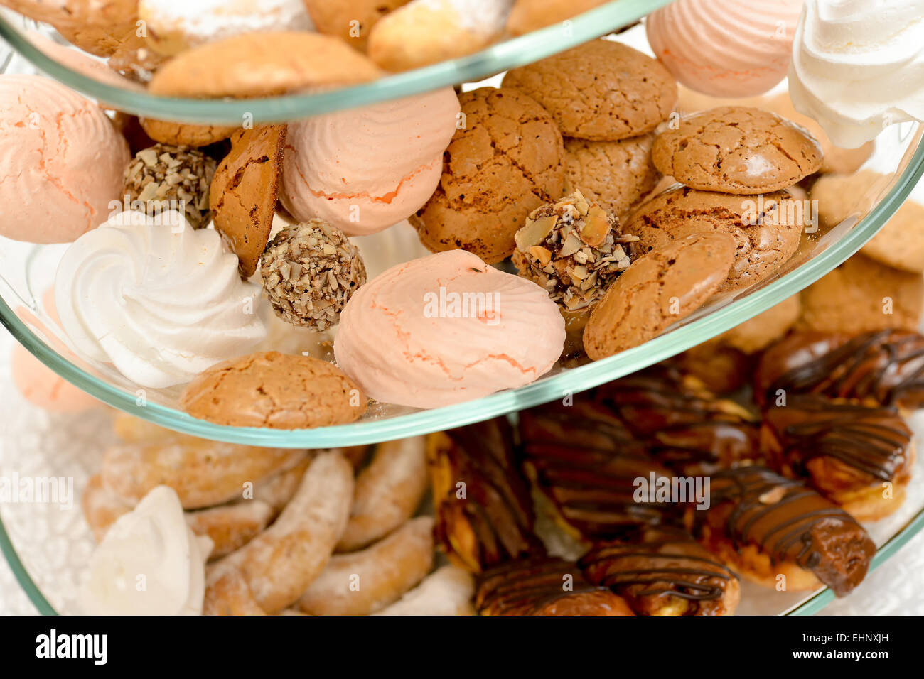 I cookies, marshmallows, ECLAIR, sfere di cioccolato con noci collocato sul supporto in vetro Foto Stock