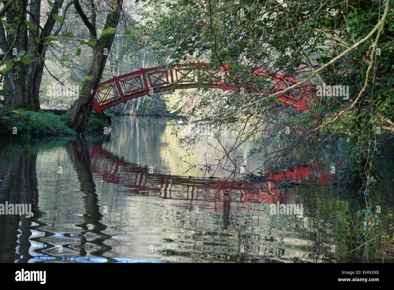 Ponte rosso e di riflessione su un lago Foto Stock