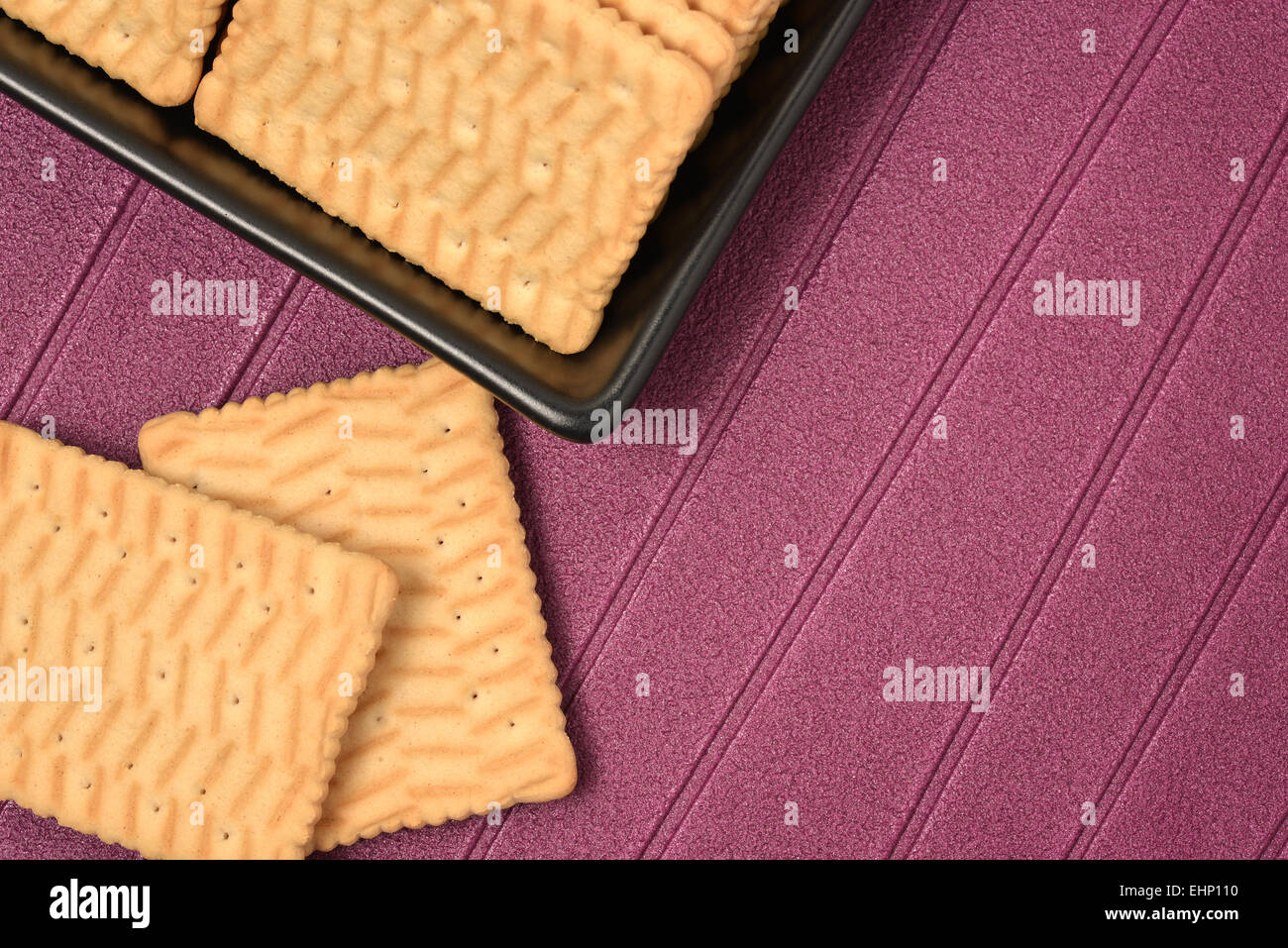 I cookie disposti in un nero vaso in ceramica con sfondo viola Foto Stock