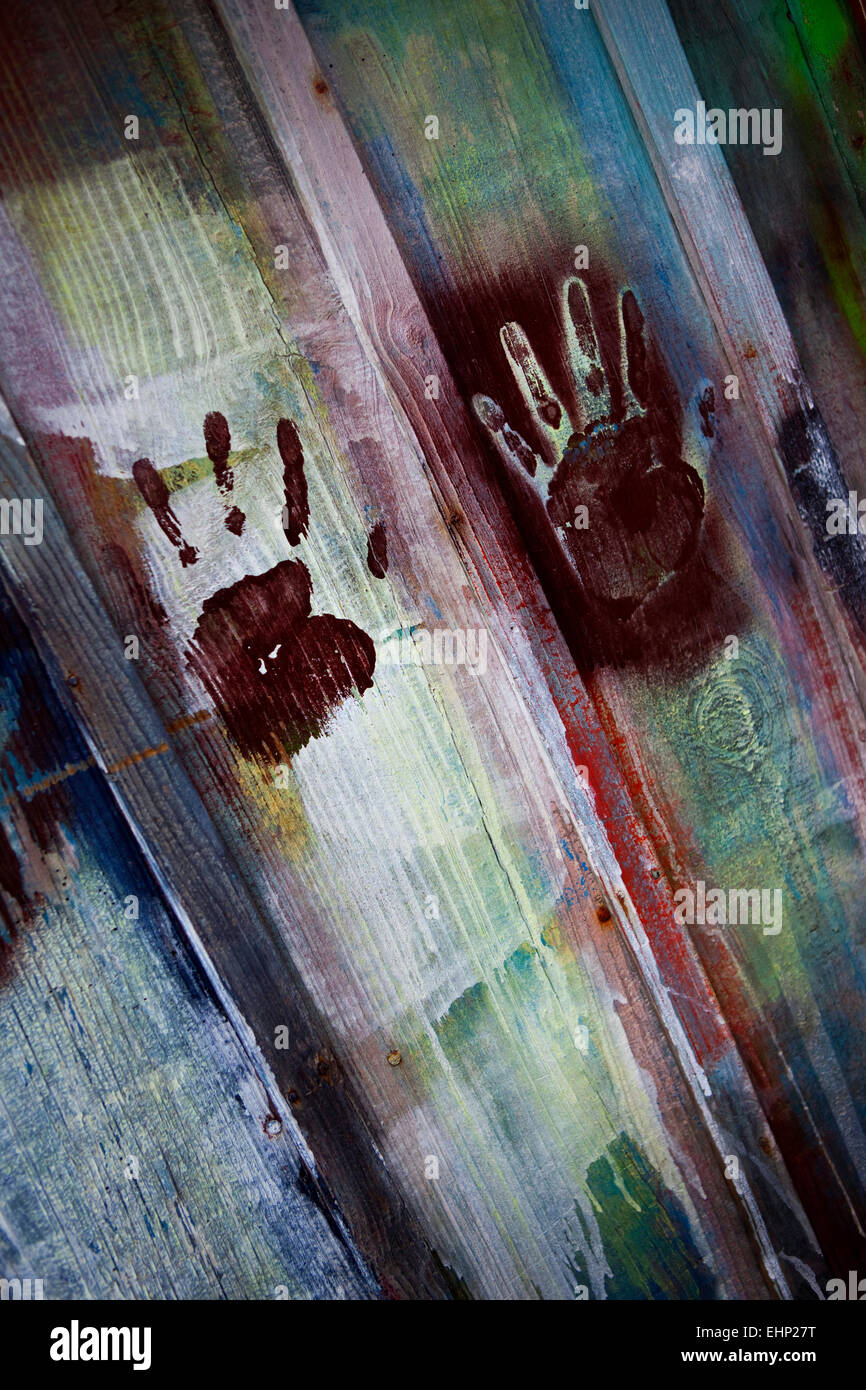 Colorate le impronte digitali su un dipinto di parete in legno Foto Stock