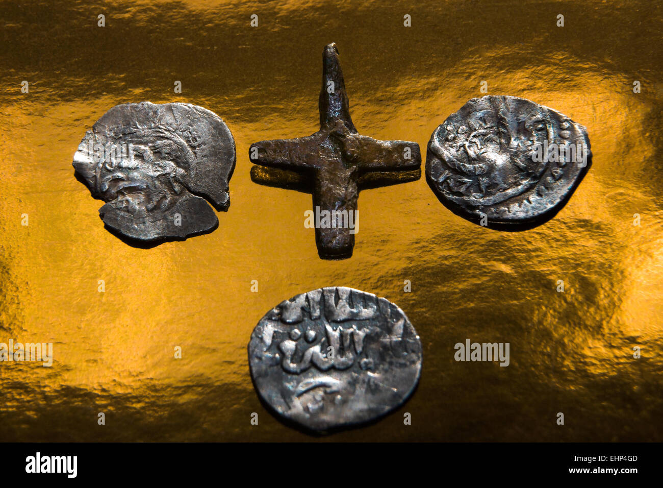 Ferro croce cristiana, uno arabo e russo due monete medievali su uno sfondo dorato Foto Stock