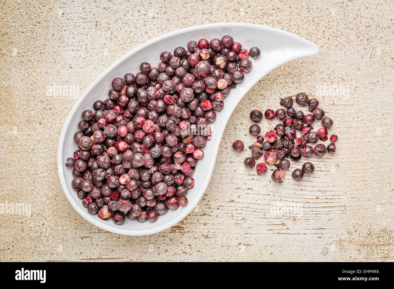 Liofilizzato sambuchi in un recipiente a goccia contro il fienile rustico di legno. Sambuchi sono ricchi di antiossidanti e minerali Foto Stock