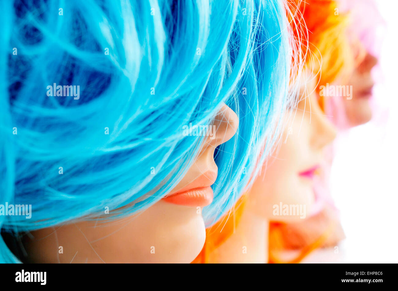Primo piano di alcuni parrucche di diversi colori sul manichino capi Foto Stock