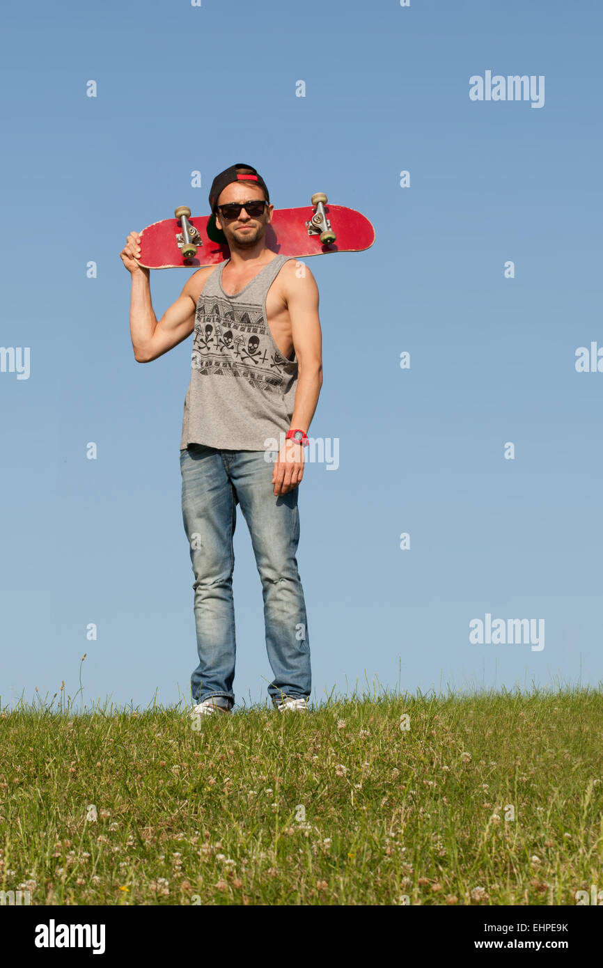 Uomo con uno skateboard Foto Stock