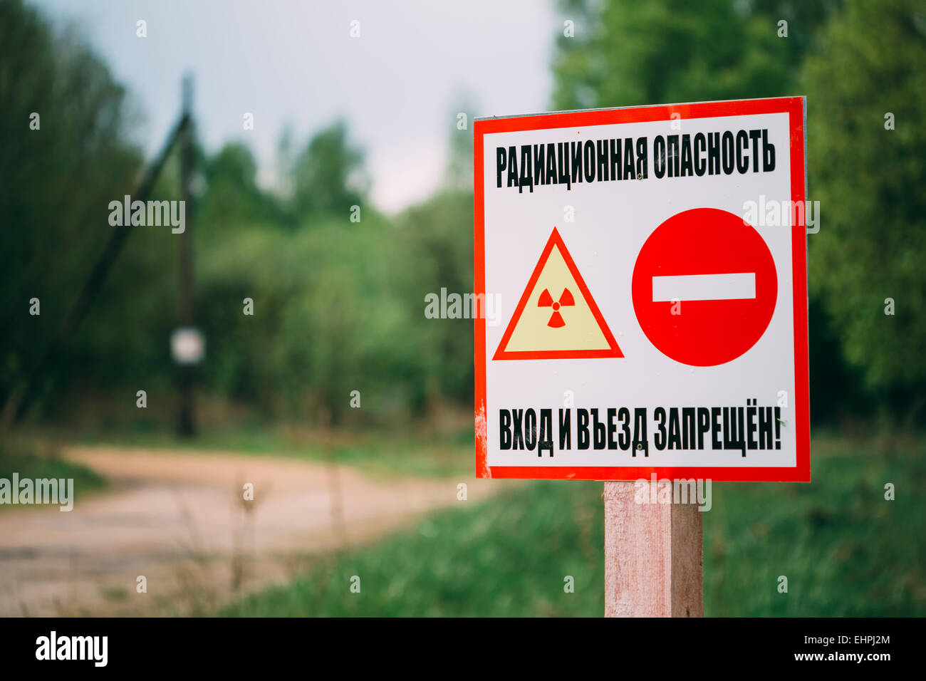 Radiazioni ionizzanti segno accanto al villaggio la Bielorussia, regione di Gomel. La zona di alienazione Foto Stock