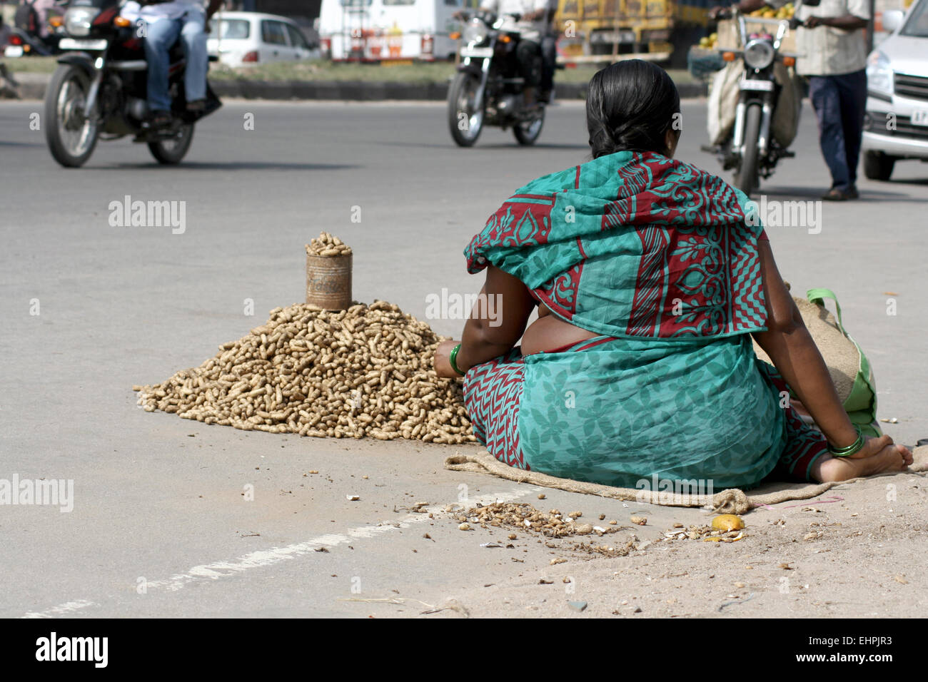 Povero indiano venditore ambulante vende noccioline o dado di massa su una strada trafficata su novembre 10,2013 in Hyderabad,AP,l'India. Foto Stock