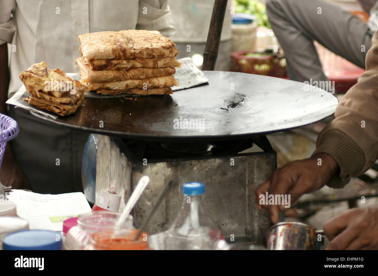 Indian venditore ambulante preparare il pane e la frittata in una strada trafficata , una scena comune in India,su settembre 18,2013 in Hyderabad, India. Foto Stock