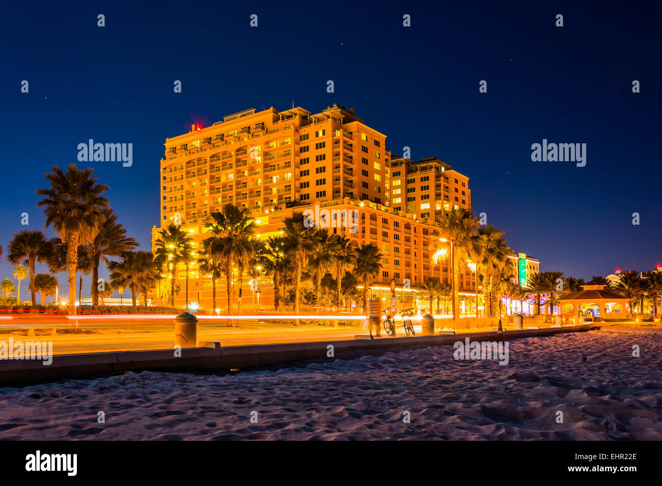 Lo spostamento del traffico passato un hotel e la spiaggia di notte, in Clearwater Beach, Florida. Foto Stock