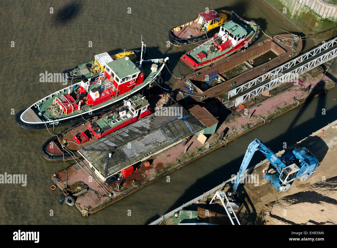 Barche da lavoro sul fiume Tamigi visto dalla compagnia aerea Emirates o Thames Funivia nelle Docklands di Londra. Foto Stock