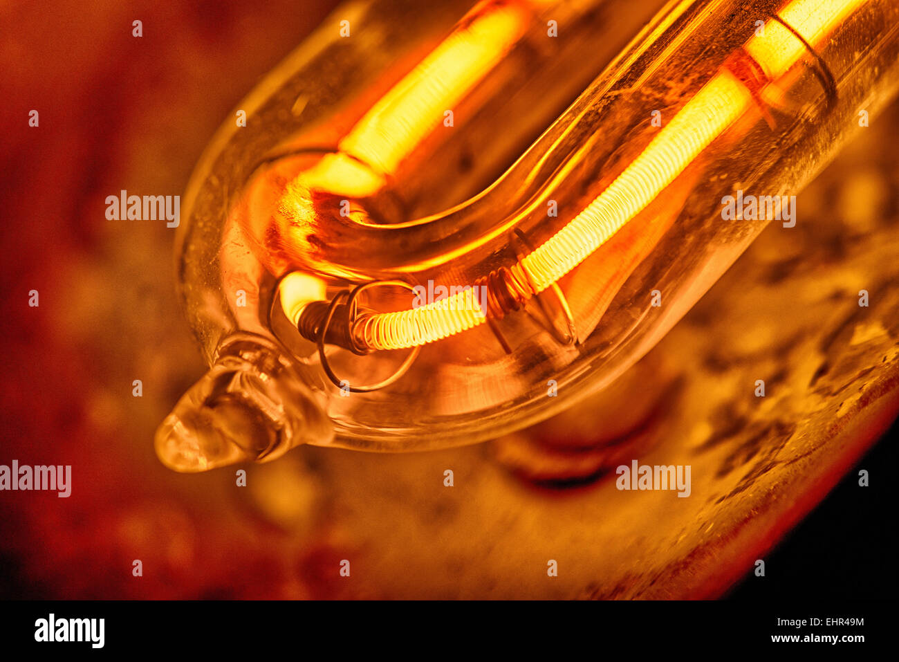 Il filamento incandescente di una 1000 lampada alogena al quarzo con scaglie di metallo e danni termici al riflettore e di erogatore di calore Foto Stock