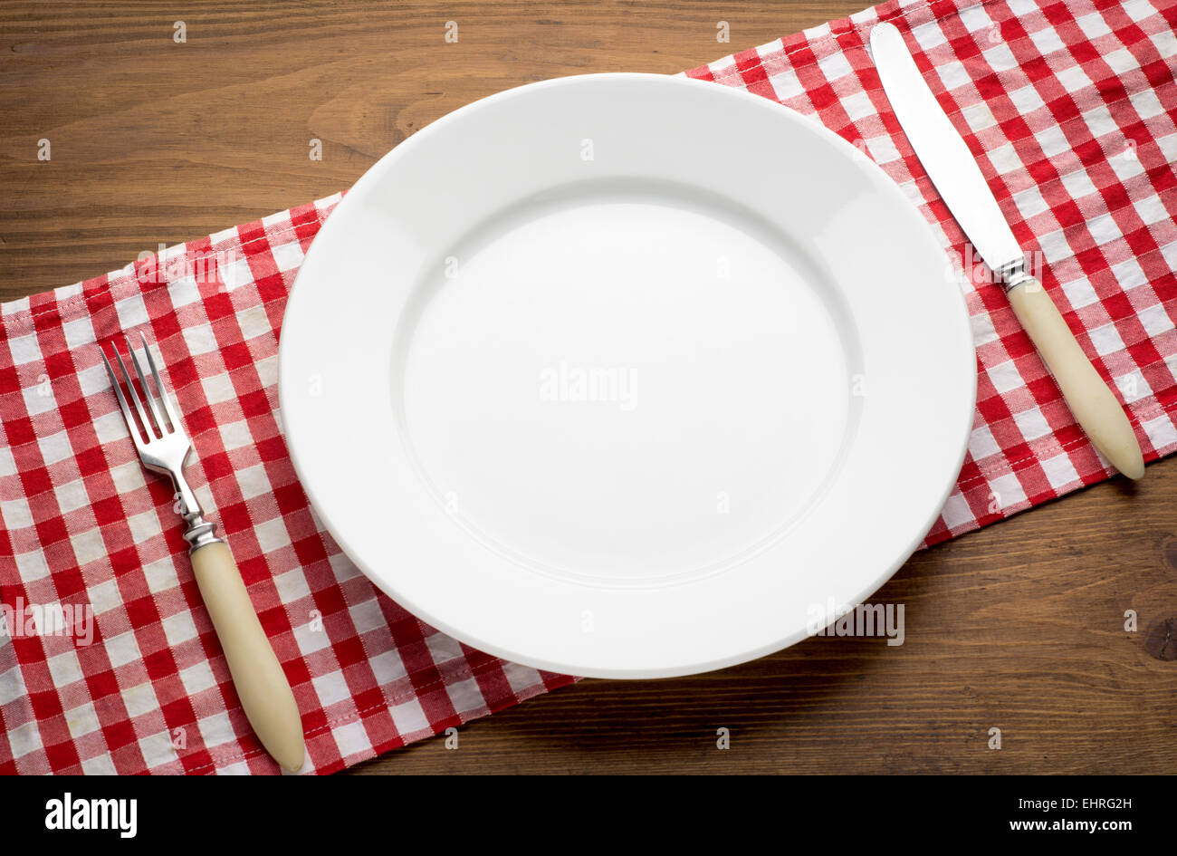 Vuoto piastra bianca sul tavolo di legno rosso su sfondo grunge Foto Stock