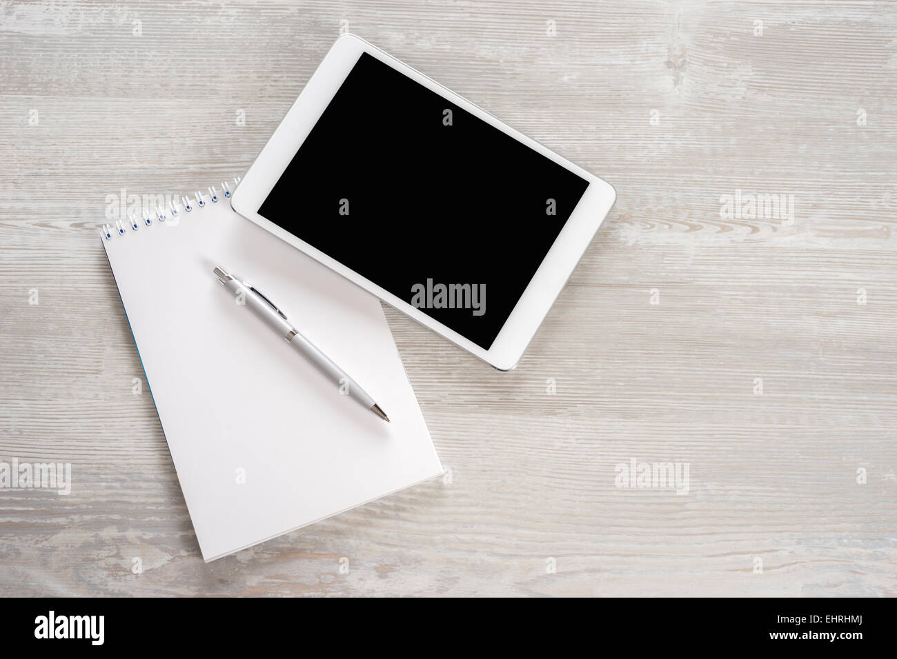 Tavoletta digitale su tavolette di legno con Blocco note e penna Foto Stock