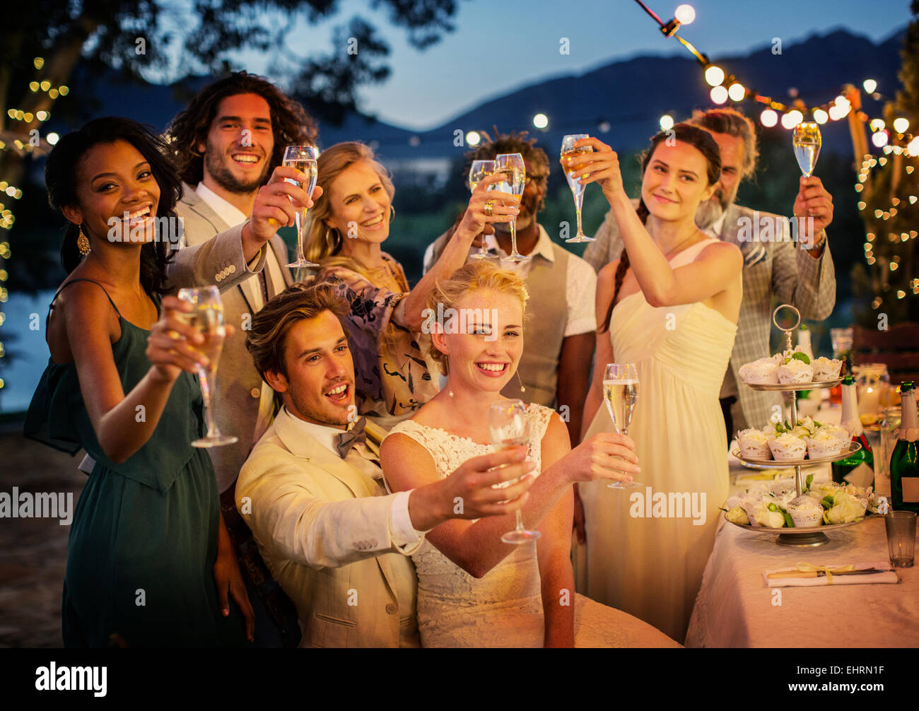 Gli ospiti dei matrimoni la tostatura con champagne durante il ricevimento di nozze in giardino Foto Stock