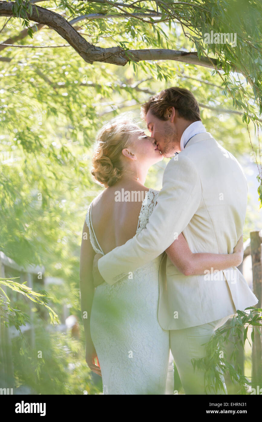 Coppia giovane kissing nel giardino interno Foto Stock