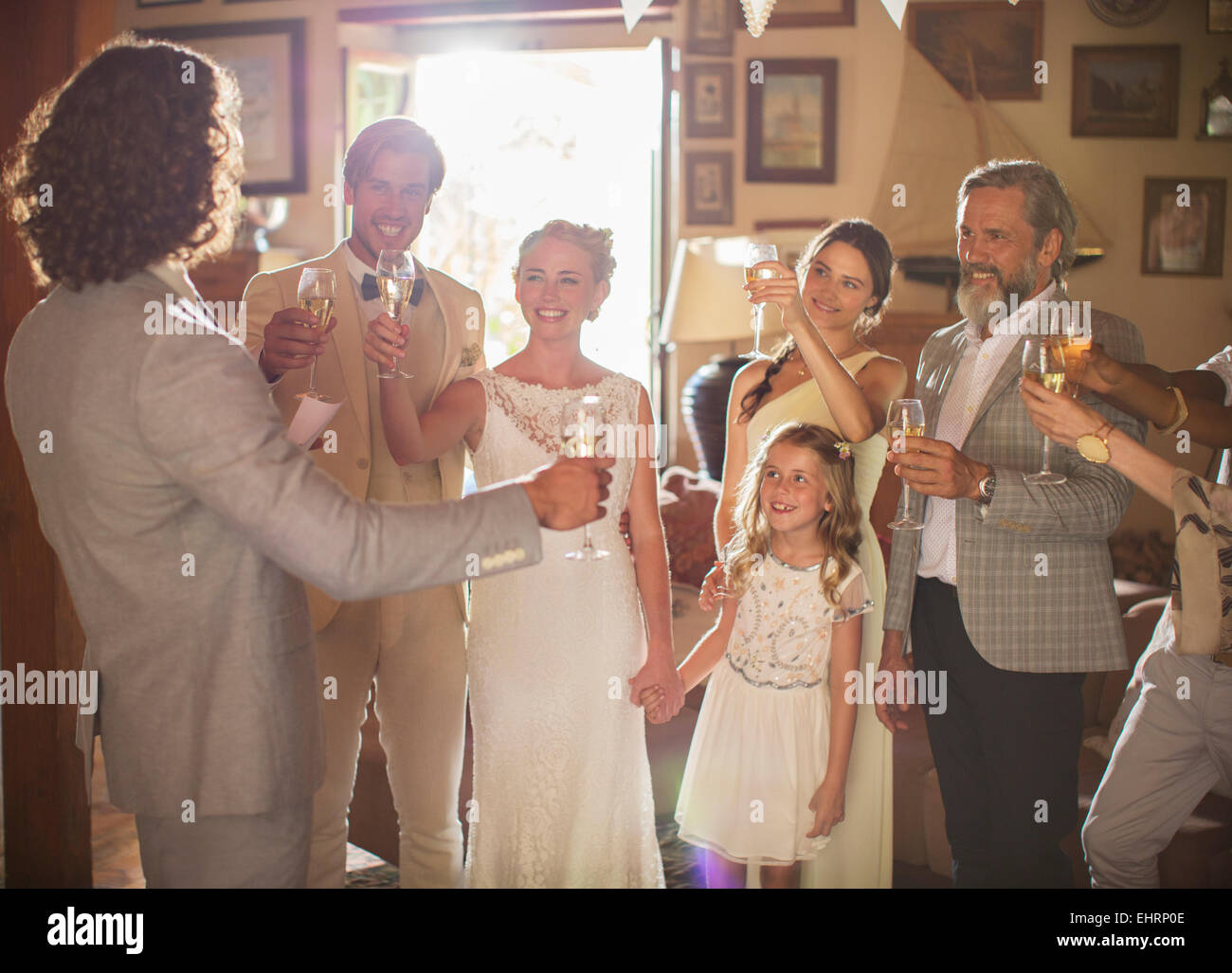 Coppia giovane e gli ospiti la tostatura con champagne al ricevimento di nozze Foto Stock