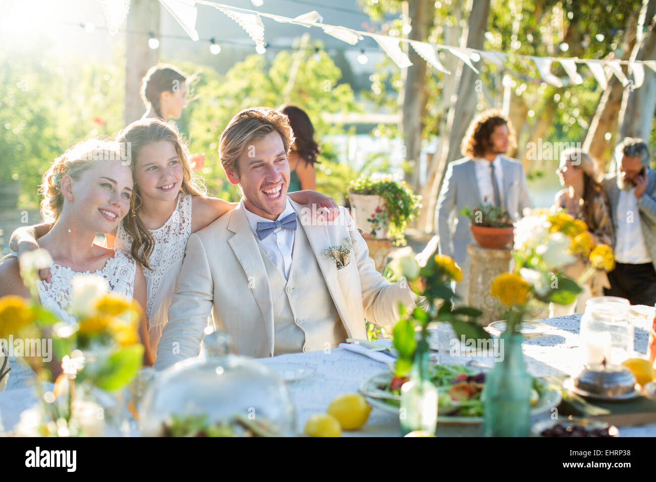 Coppia giovane e damigella durante il ricevimento di nozze nel giardino interno Foto Stock