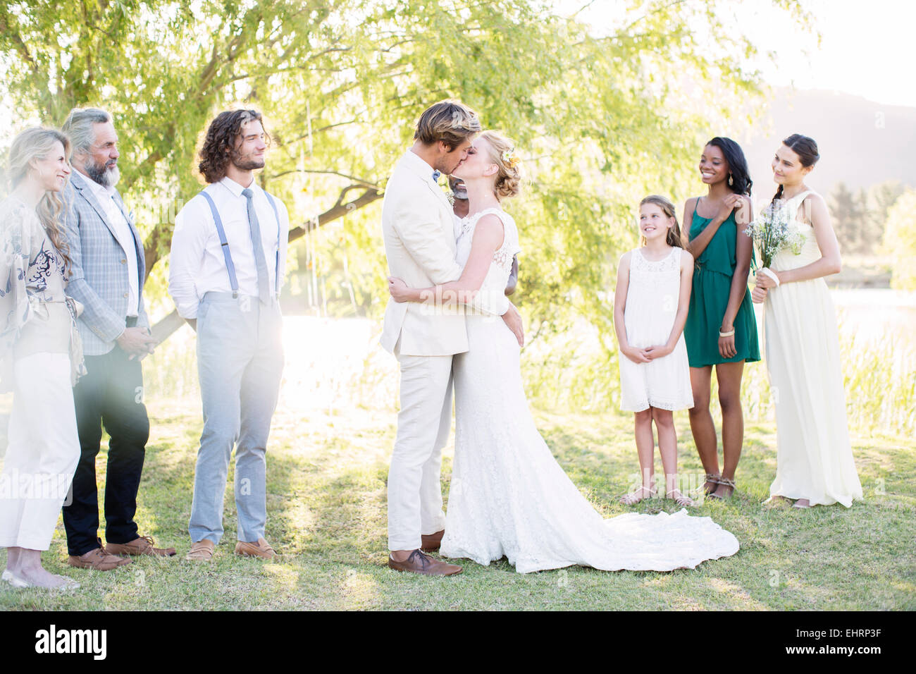 Coppia giovane abbracciando e baciando durante la cerimonia di matrimonio nel giardino interno Foto Stock