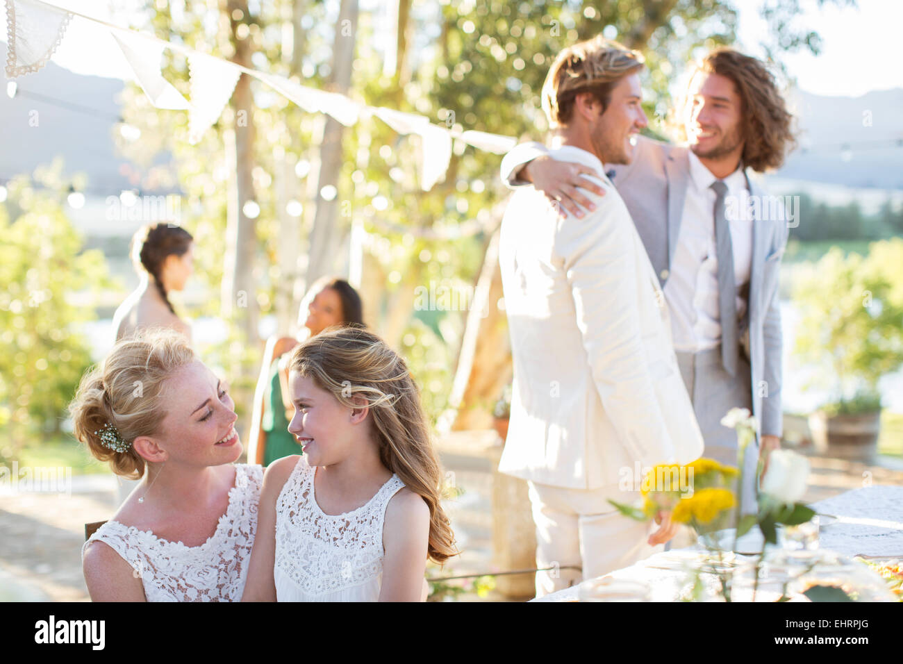 Sposa parlando di damigella durante il ricevimento di nozze nel giardino interno Foto Stock