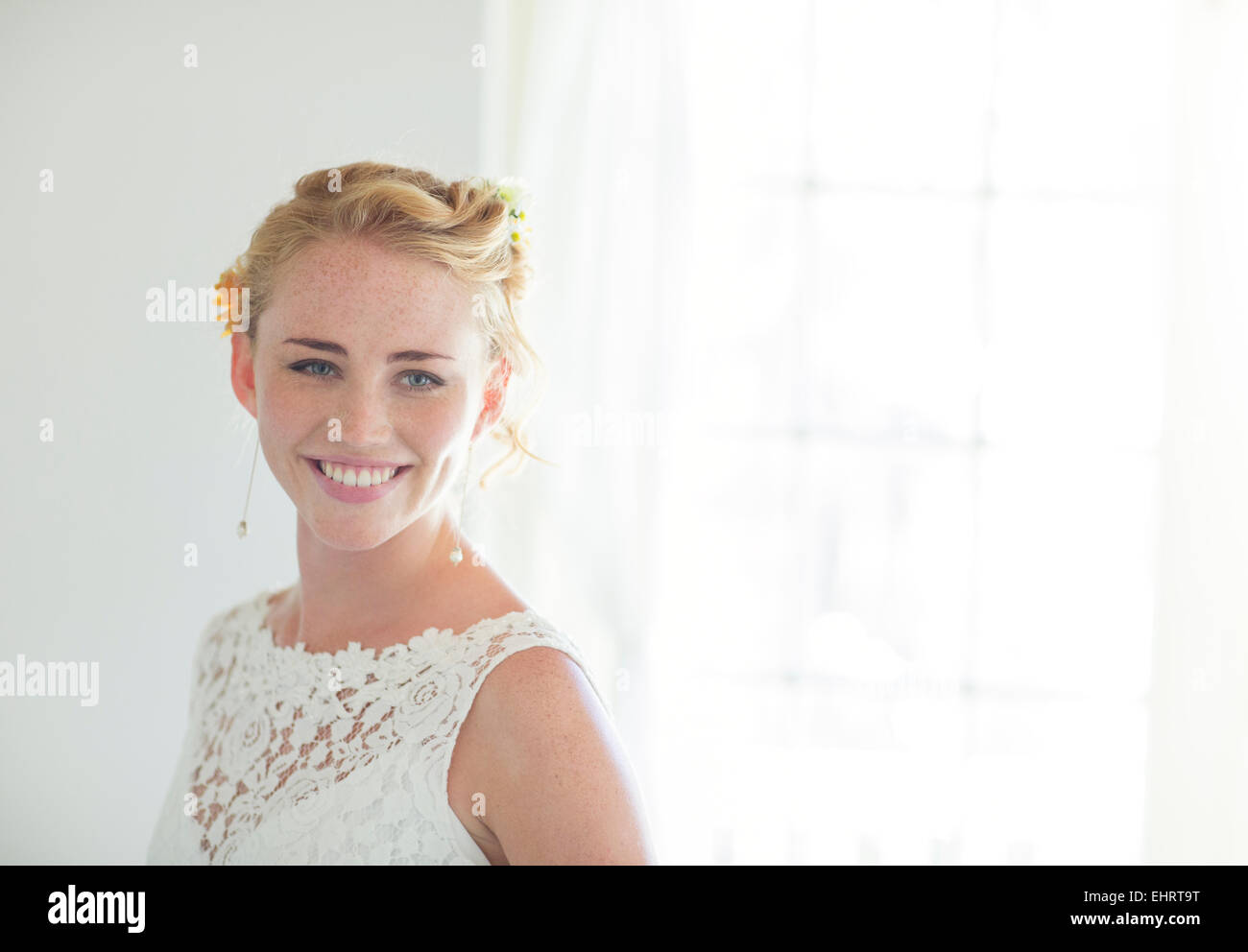 Ritratto di sposa sorridente in stanza soleggiata Foto Stock