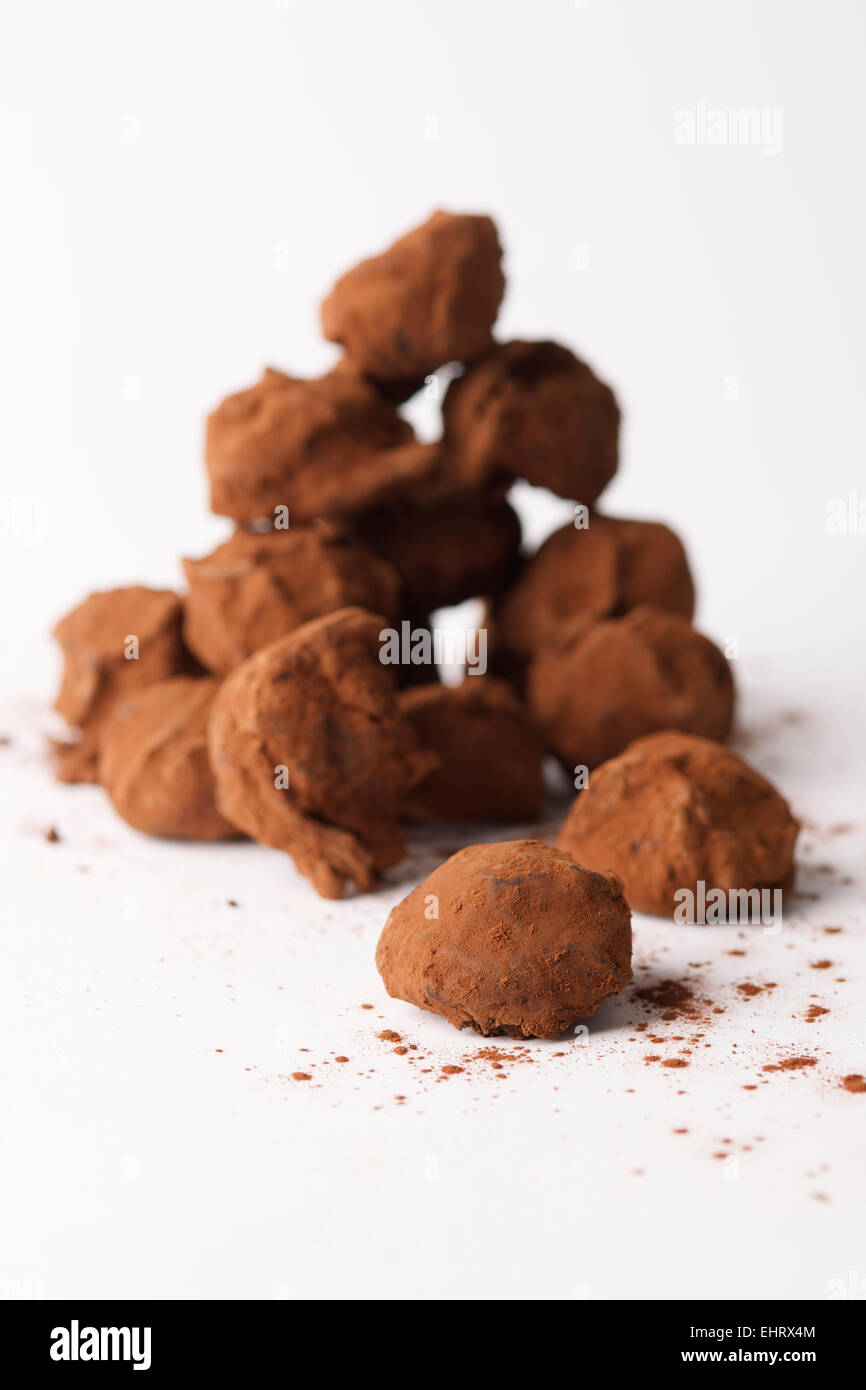 Una piccola pila di tartufi di cioccolato su sfondo bianco Foto Stock