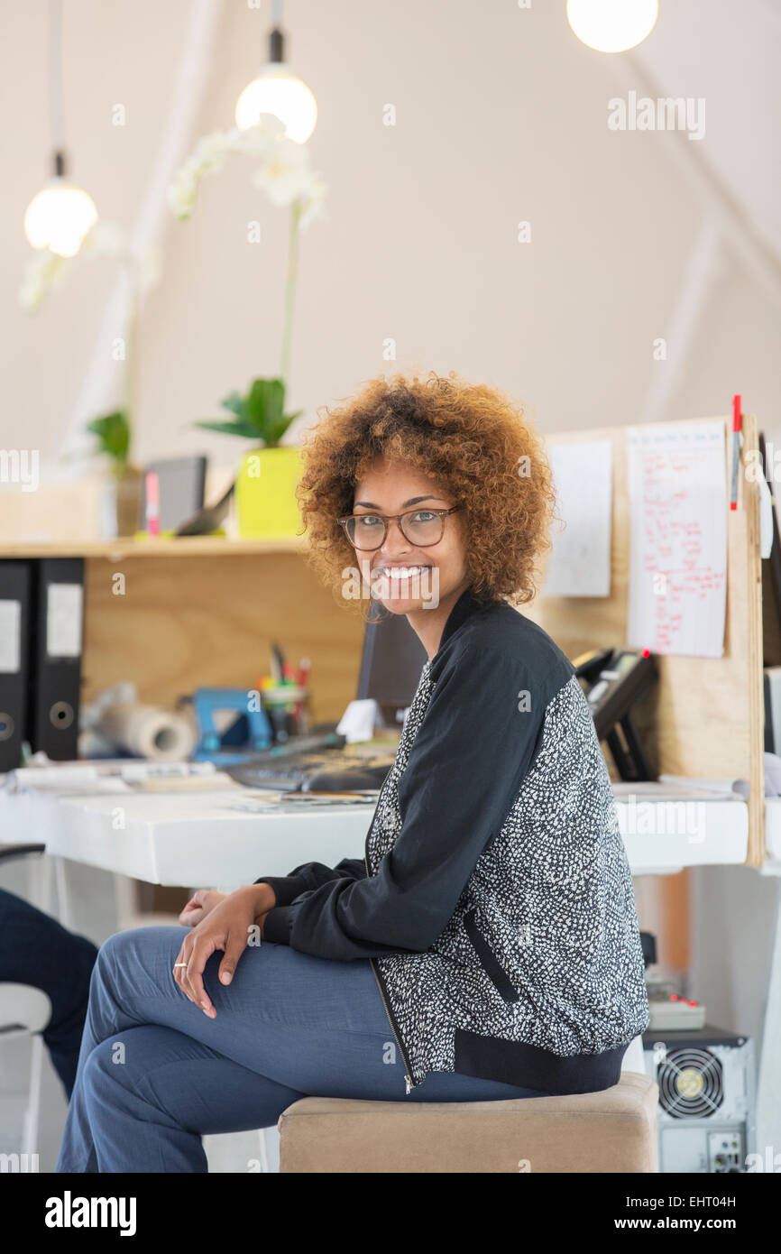 Ritratto di donna seduta in ufficio e sorridente Foto Stock