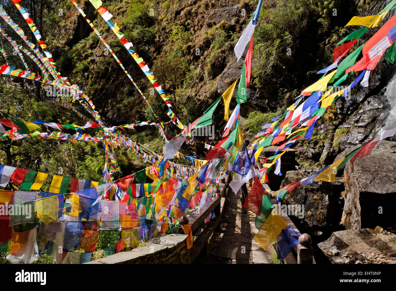 Il Bhutan - una pletora di bandiere di preghiera da una cascata vicino all'entrata Taktshang Goemba, (Tiger's Nest monastero). Foto Stock